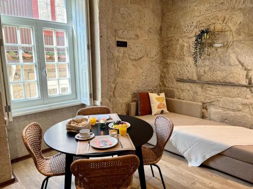 um quarto com uma mesa e cadeiras com uma cama em Oca Ribeira do Porto AT em Porto