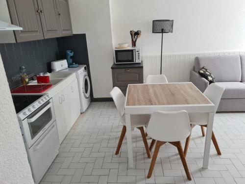 - une cuisine avec une table, une table et des chaises dans l'établissement Appartement centre ville proche citadelle, au Château-dʼOléron