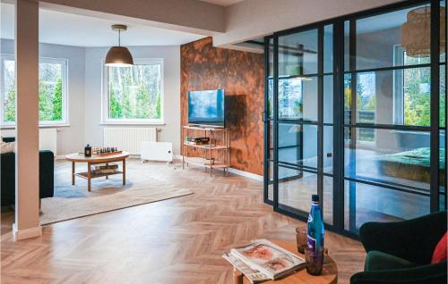 a living room with a couch and a table and a tv at Awesome Apartment In Stezyca With Sauna in Stężyca