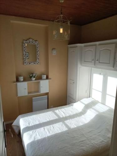 サン・マルタン・ヴェジュビーにあるLumineux 2 pièces à St Martinのベッドルーム(大きな白いベッド1台、鏡付)