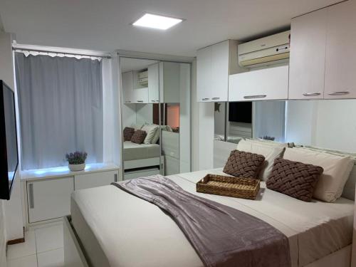 a bedroom with a large bed and a living room at Luxor Tambaú Beach Paradise in João Pessoa