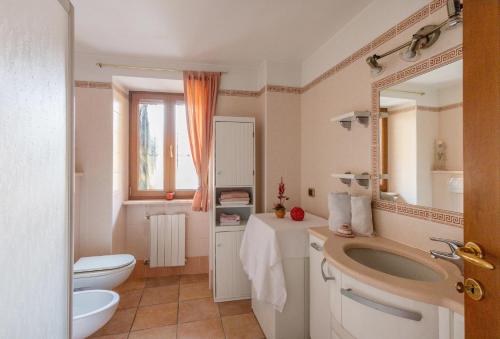 La salle de bains est pourvue d'un lavabo, de toilettes et d'un miroir. dans l'établissement L'Angolo delle Peonie, à Cannobio
