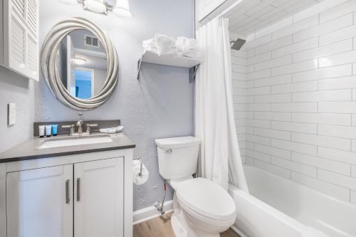 een badkamer met een toilet, een wastafel en een spiegel bij Plantation East in Gulf Shores