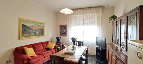 salon z czerwoną kanapą i stołem w obiekcie La Casa di Amelie w mieście Parma