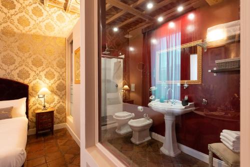 a bathroom with a toilet and a sink and a tub at Le Suite del Barone in Rome