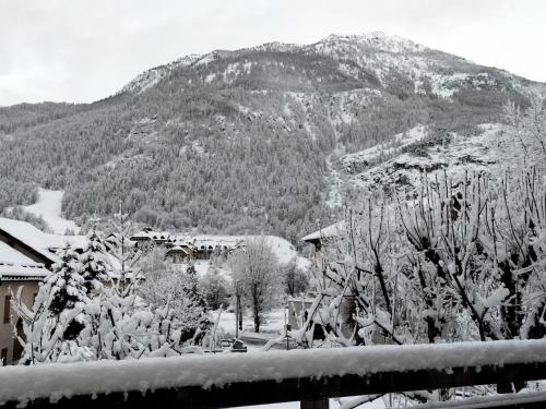 a snow covered mountain in front of a house at Chalet Nicouski in La Salle Les Alpes