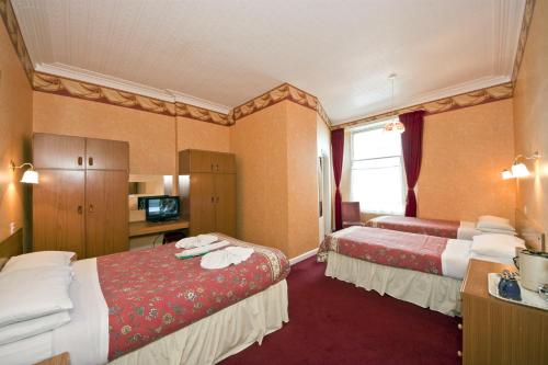 Ένα ή περισσότερα κρεβάτια σε δωμάτιο στο Abbey Court Hotel