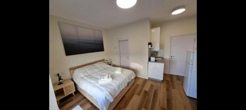 a bedroom with a white bed and a kitchen at Jaffa 17 - Lihi brand new studio in Jerusalem
