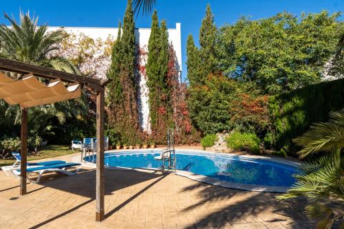 a swimming pool in a garden with a fountain at Hotel Checkin Valencia Ciscar in Picanya
