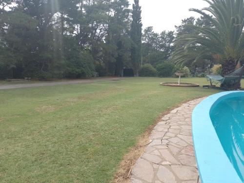 un patio trasero con piscina y césped en Quinta Don Alfredo en Tandil