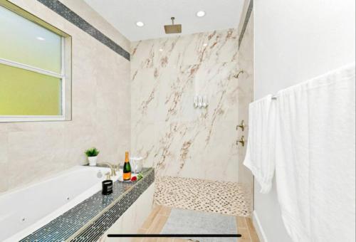 uma casa de banho branca com uma banheira e um chuveiro em Orlando FL. te mereces lo mejor, esta magnifica villa em Orlando
