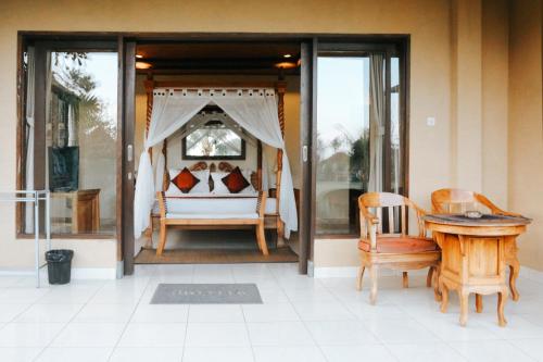 una camera con letto, tavolo e sedie di Sri Aksata Ubud Resort by Adyatma Hospitality ad Ubud