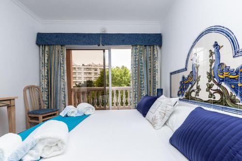 a bedroom with a large bed and a window at Parque dos Reis Apartment in Monte Gordo