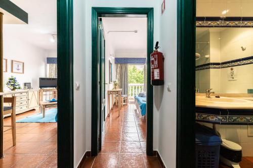 un pasillo que conduce a una cocina con fregadero en Parque dos Reis Apartment, en Monte Gordo