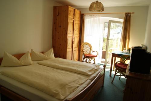 a bedroom with a bed and a table and chairs at Pension Waldeck in Göhren