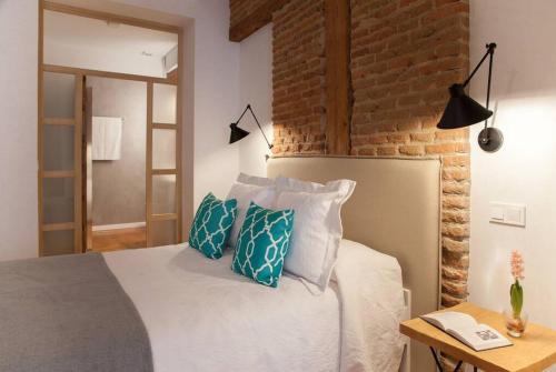 - une chambre avec un lit doté d'oreillers bleus et blancs dans l'établissement Apartamento en el centro la ciudad, à Madrid
