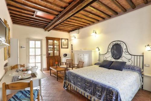 um quarto com uma cama, uma mesa e cadeiras em Casale Pozzo al Moro em Marina di Campo