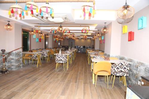 una sala da pranzo con tavoli, sedie e luci di Cardinal Express Oxmo a Nuova Delhi