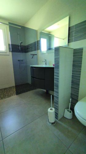 une salle de bain avec un lavabo, une douche et des toilettes dans l'établissement L'Ostal Randoleta, à Abeilhan