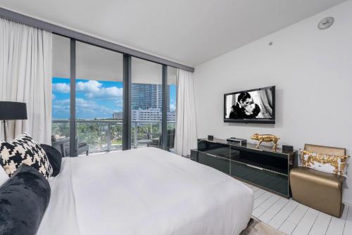 - une chambre avec un grand lit et une grande fenêtre dans l'établissement Ocean View Residence at W South Beach -514, à Miami Beach