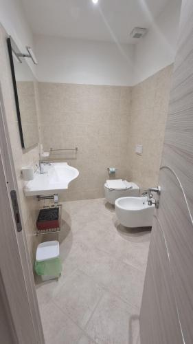a bathroom with two sinks and a tub and a toilet at ValGiuSi Resort in Capo Vaticano