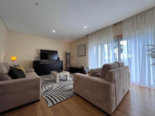 a living room with two couches and a television at Lovely&Charming Anita’s apartment in Ponta Delgada