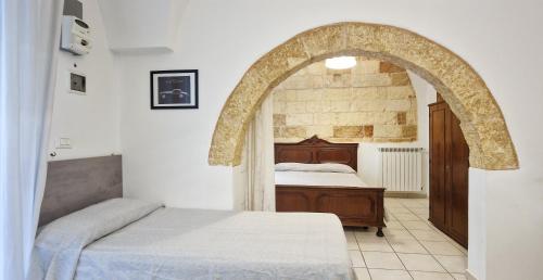 1 dormitorio con 1 cama y un arco en Palazzotto la Volta - Tricase, en Tricase