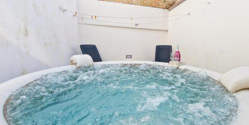una bañera llena de agua azul en una habitación en Palazzotto la Volta - Tricase, en Tricase