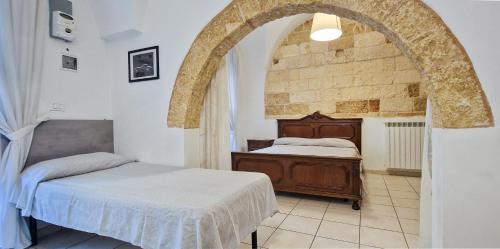 a bedroom with two beds and an archway at Palazzotto la Volta - Tricase in Tricase