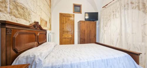 a bedroom with a bed with a wooden head board at Palazzotto la Volta - Tricase in Tricase