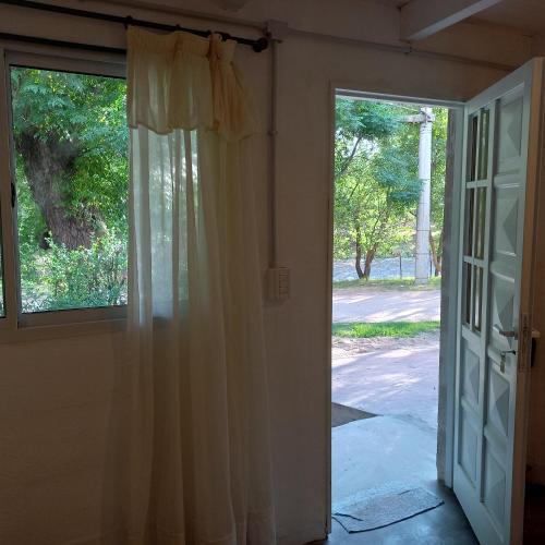 una puerta abierta a una habitación con ventana en Villa Cura Brochero - La Moradita de VIlla Los Sauces en Villa Cura Brochero