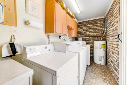 a kitchen with white appliances and a brick wall at Tranquil Trail #3 in Carefree