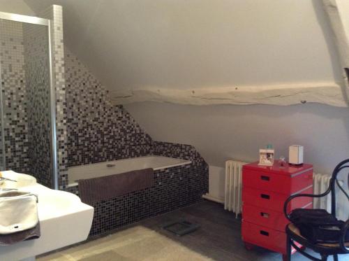 a bathroom with a sink and a tub in a room at La Chaumière - petit-déjeuner inclus à 15 min de Versailles in Jouars-Pontchartrain