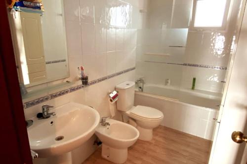 een badkamer met een wastafel, een toilet en een bad bij Apartamento a unos pasos de la Playa (Rota) in Rota