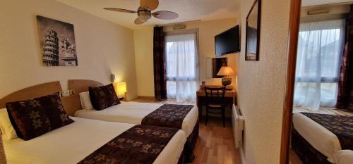 a hotel room with two beds and a table at Kyriad Direct Arpajon in Arpajon