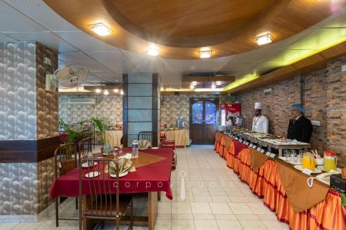 a restaurant with two chefs standing in the kitchen at Sel Nibash Hotel & Serviced Apartments in Dhaka