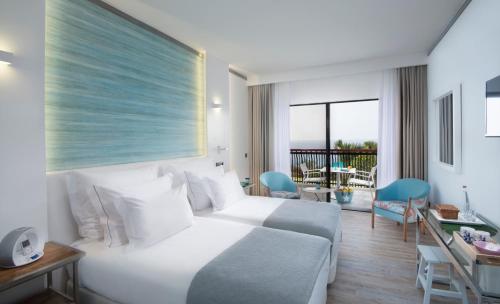 Habitación de hotel con cama y balcón en Hotel Baia Azul en Funchal