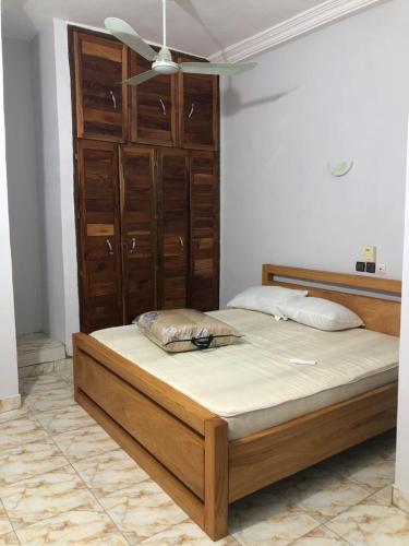 a bedroom with a large bed with a ceiling fan at PARADISE HY in Cotonou