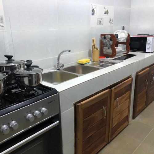 a kitchen with a sink and a stove at PARADISE HY in Cotonou