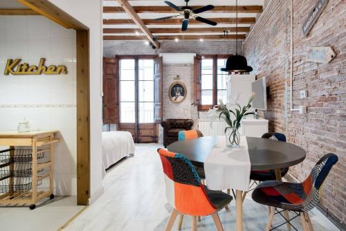 バルセロナにあるLovely loft near Barcelona centerのレンガの壁のダイニングルーム(テーブル、椅子付)