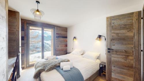 a bedroom with a bed and a large window at Ecureuil noir COSY & QUIET chalet 10 personnes in Vex