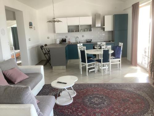 a living room and kitchen with a couch and a table at Villa Jadranka Rab apartman Nick in Rab