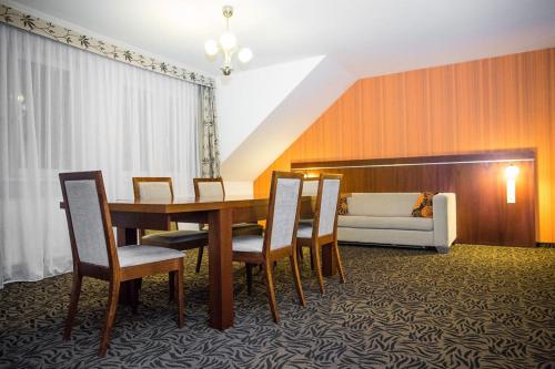 uma sala de jantar com uma mesa e cadeiras e um sofá em Pokoje hotelowe Azyl em Katy Wroclawskie