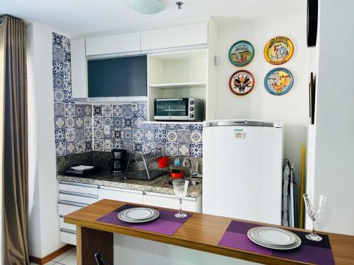 a kitchen with a table and a refrigerator at loft london, conforto no coração de Icarai in Niterói