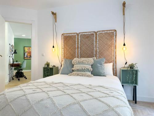 a bedroom with a large bed with a metal headboard at Elegante apartamento a unos pasos de la Rambla. in Alicante