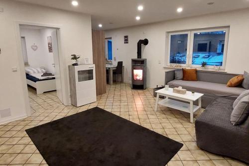 a living room with a couch and a stove at Ferien-/Monteurwohnung im Odw. in Mörlenbach