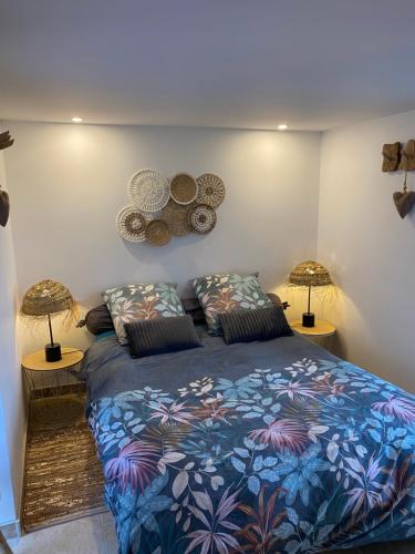 a bedroom with a blue bed with two lamps at Tiny housse la Poitevinière in Neuillé