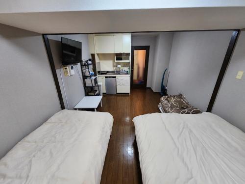 Habitación pequeña con 2 camas y cocina en MORI Apartment2 道頓堀(Dotonbori) 1K, en Osaka