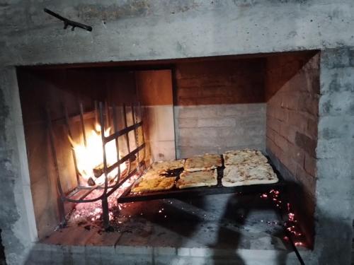 Un horno de ladrillo con algo de comida dentro. en Las Caetanitas, en Costa Azul