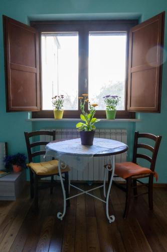 a table and chairs in a kitchen with two windows at AnimAbruzzo in Cepagatti